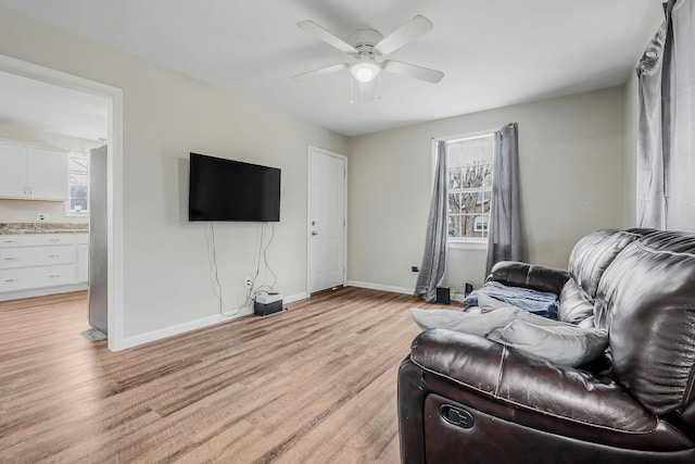 living room with ceiling fan and light hardwood / wood-style flooring