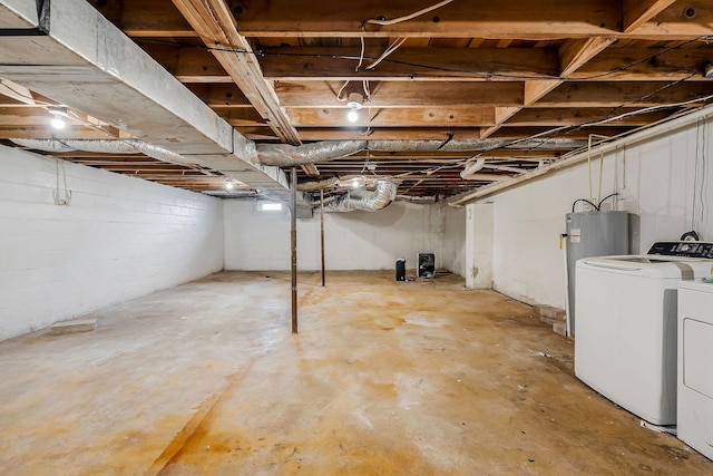 basement featuring electric water heater and separate washer and dryer