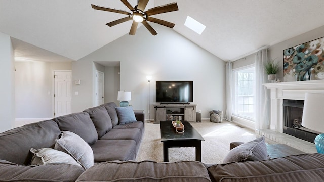 living room featuring light colored carpet, lofted ceiling with skylight, and ceiling fan