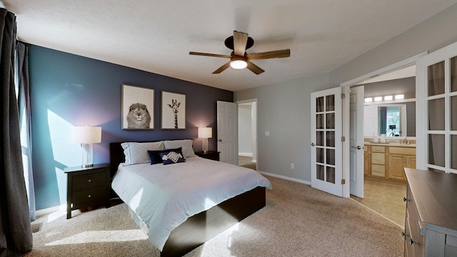 carpeted bedroom featuring connected bathroom, ceiling fan, and sink