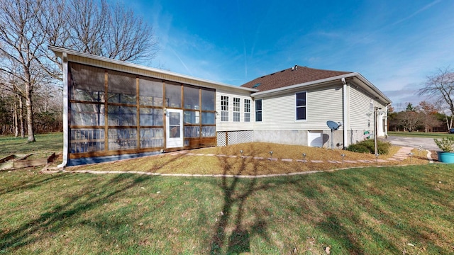 rear view of house with a sunroom and a yard