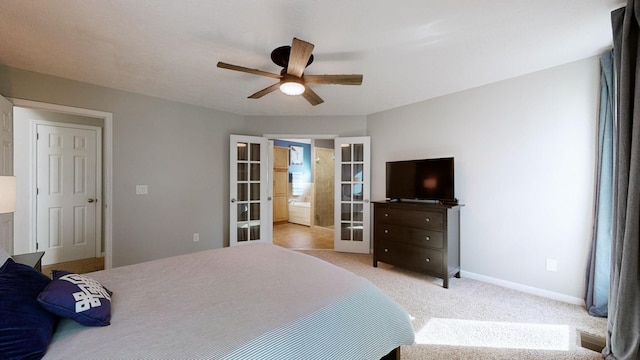 bedroom featuring light carpet, french doors, ensuite bathroom, and ceiling fan