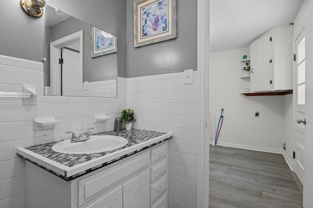 bathroom with wood-type flooring, vanity, and tile walls