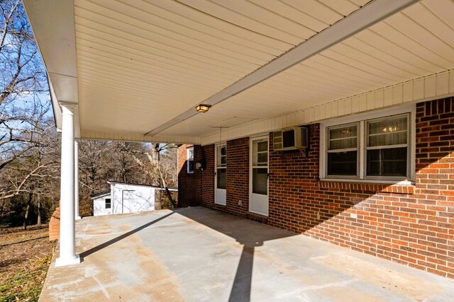 view of patio with a wall unit AC