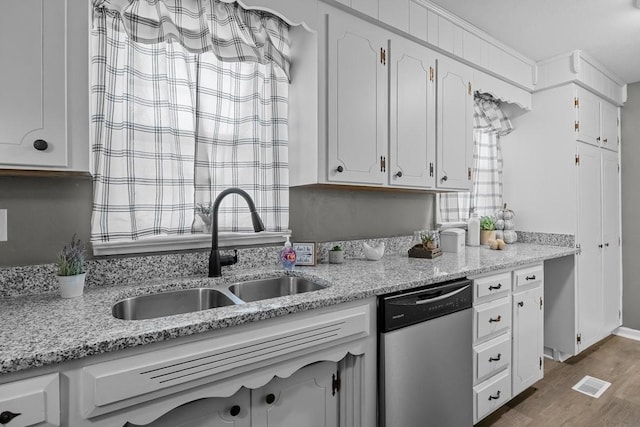 kitchen featuring dishwasher, dark hardwood / wood-style flooring, white cabinets, and sink