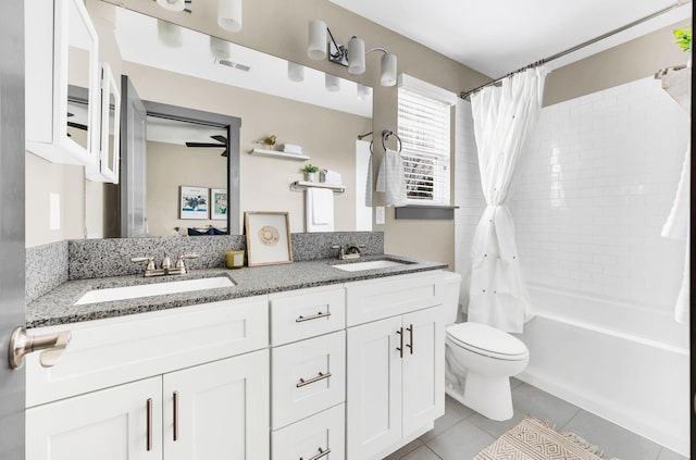 full bathroom with shower / bath combo, tile patterned floors, vanity, ceiling fan, and toilet