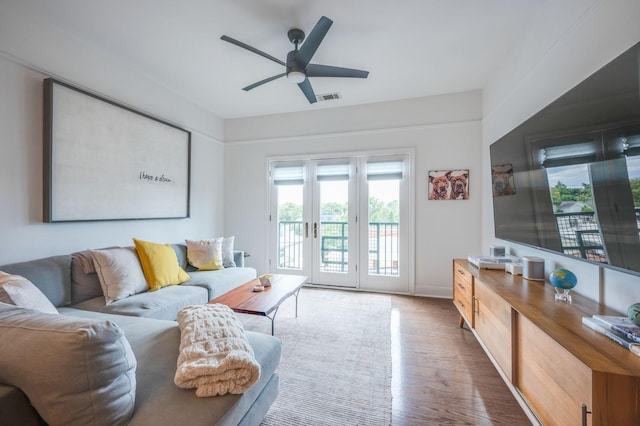 living room featuring ceiling fan, french doors, and wood-type flooring