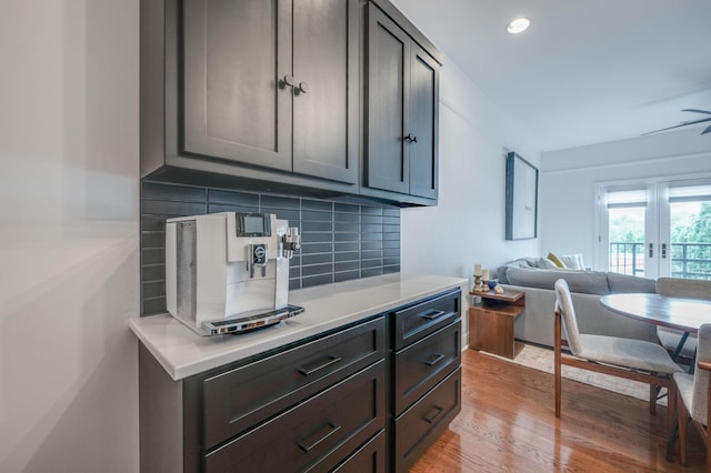 interior space featuring decorative backsplash, french doors, light hardwood / wood-style flooring, and ceiling fan