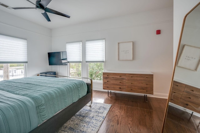 bedroom with ceiling fan, dark hardwood / wood-style floors, and multiple windows