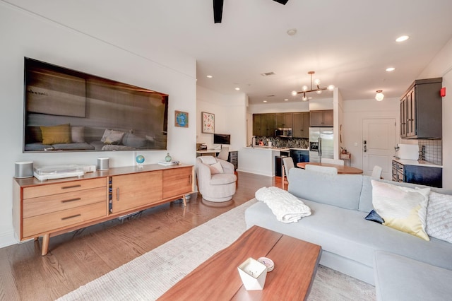 living room featuring wood-type flooring and a notable chandelier