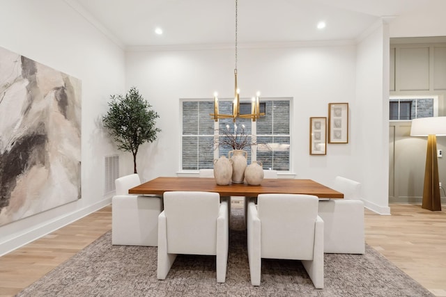 dining room featuring visible vents, light wood-style floors, and ornamental molding