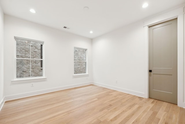 spare room featuring visible vents, a healthy amount of sunlight, baseboards, recessed lighting, and light wood-style floors