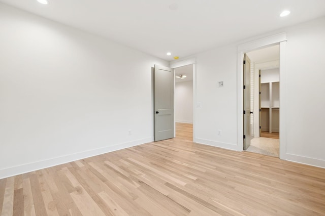 unfurnished bedroom with recessed lighting, light wood-style flooring, and baseboards