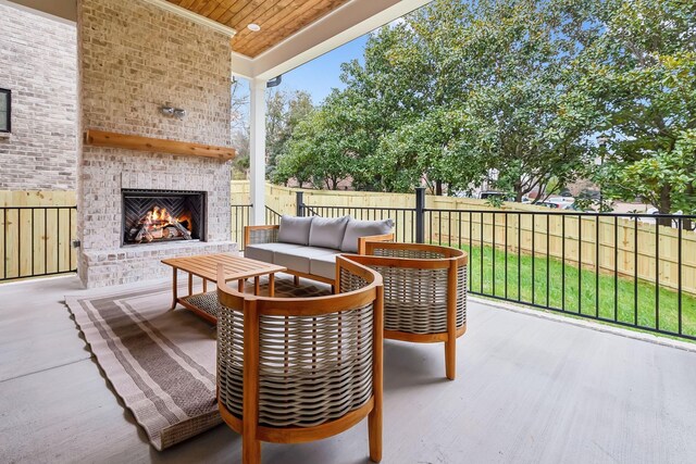 view of patio featuring an outdoor living space with a fireplace and a fenced backyard