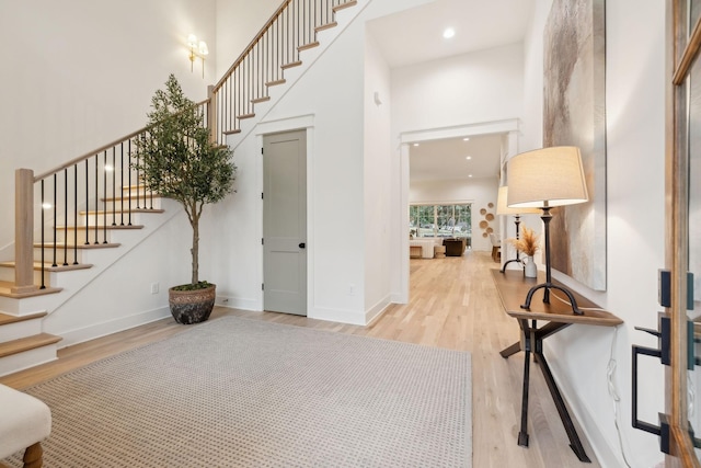 entrance foyer featuring wood finished floors, recessed lighting, a high ceiling, baseboards, and stairs