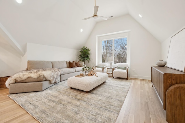 living room featuring visible vents, baseboards, vaulted ceiling, light wood-style flooring, and a ceiling fan