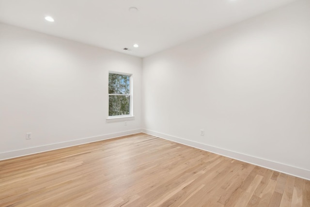 empty room featuring recessed lighting, baseboards, and light wood-style floors