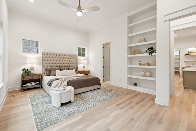 bedroom featuring crown molding, a ceiling fan, light wood-type flooring, and baseboards