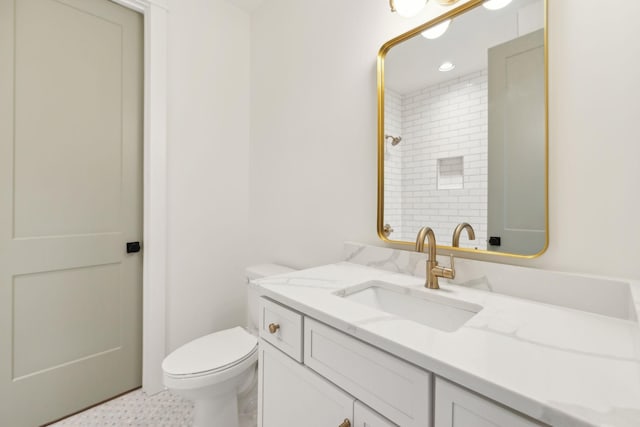 bathroom featuring toilet, vanity, and a shower