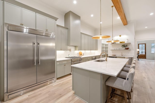 kitchen with beamed ceiling, high quality appliances, a sink, backsplash, and wall chimney exhaust hood