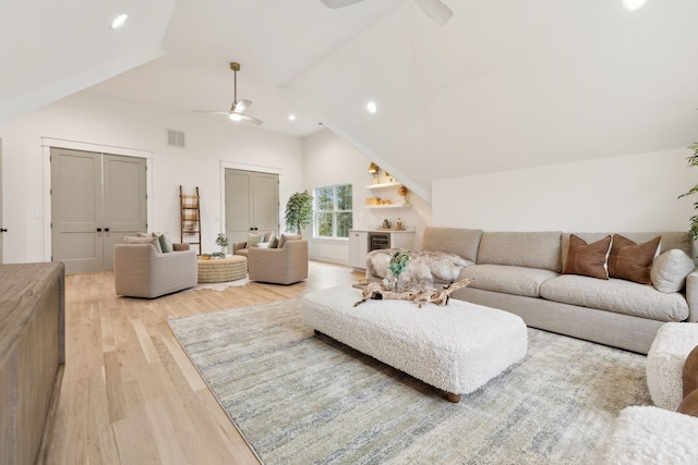 living room with lofted ceiling, light wood-style floors, visible vents, and ceiling fan