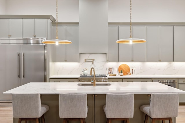 kitchen featuring light stone counters, decorative backsplash, appliances with stainless steel finishes, and pendant lighting