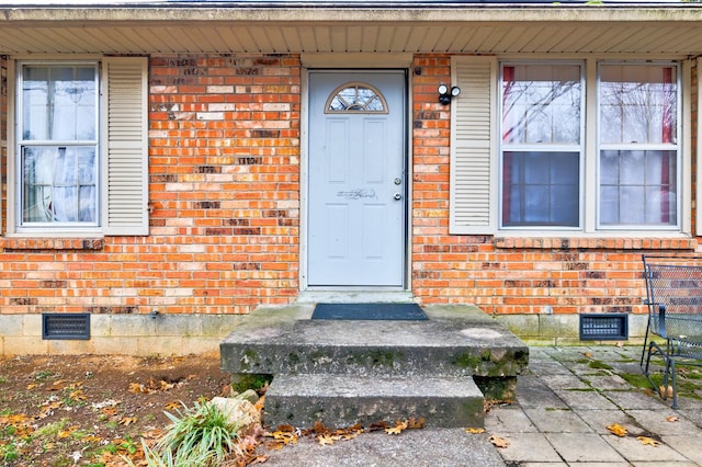 entrance to property with crawl space and brick siding