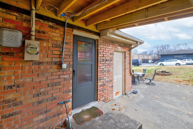 entrance to property with a patio area, brick siding, and outdoor dining area