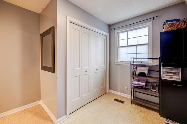 interior space with visible vents, light carpet, and baseboards