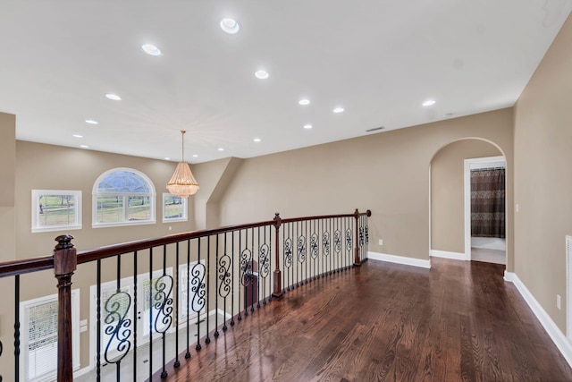 hall with dark hardwood / wood-style floors and an inviting chandelier