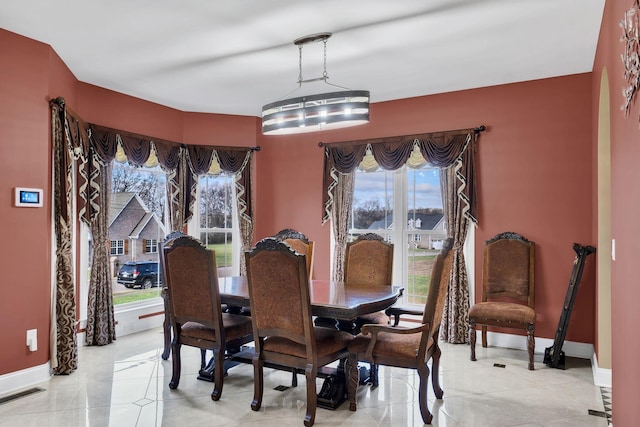 dining space featuring light tile patterned floors and a notable chandelier