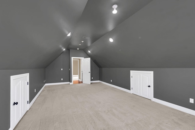 bonus room featuring lofted ceiling and light carpet