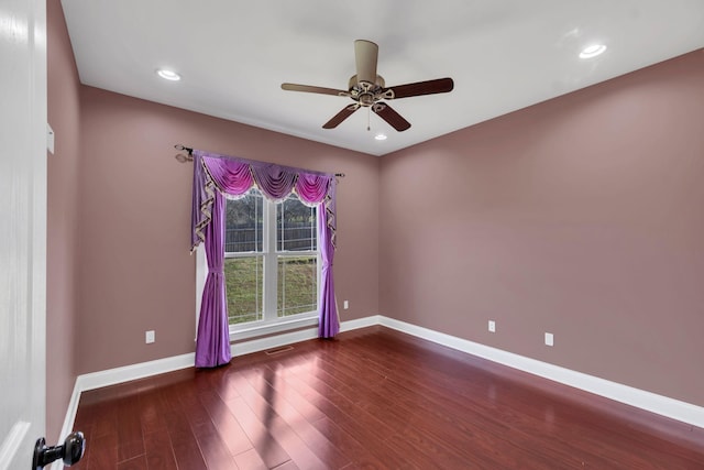 spare room with ceiling fan and dark wood-type flooring