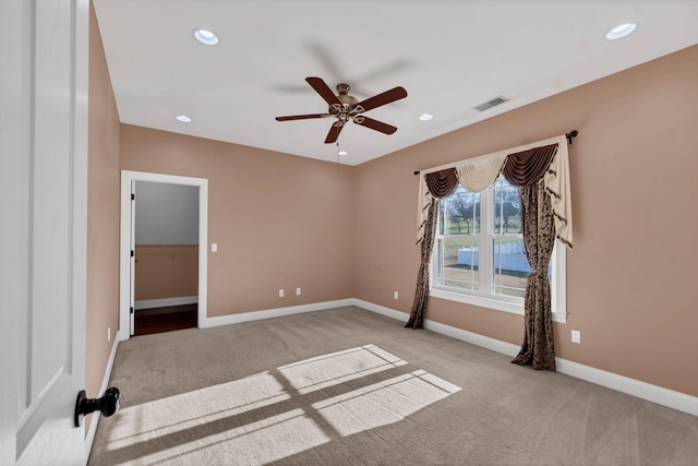 carpeted spare room with ceiling fan