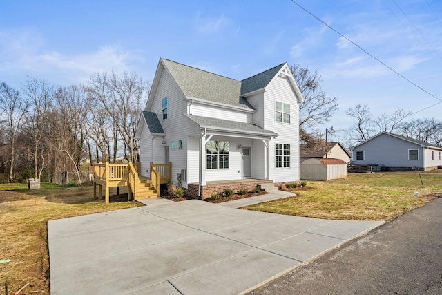 view of property with a shed, a wooden deck, and a front lawn