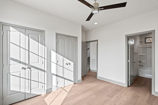 unfurnished bedroom featuring ensuite bathroom, ceiling fan, and light wood-type flooring