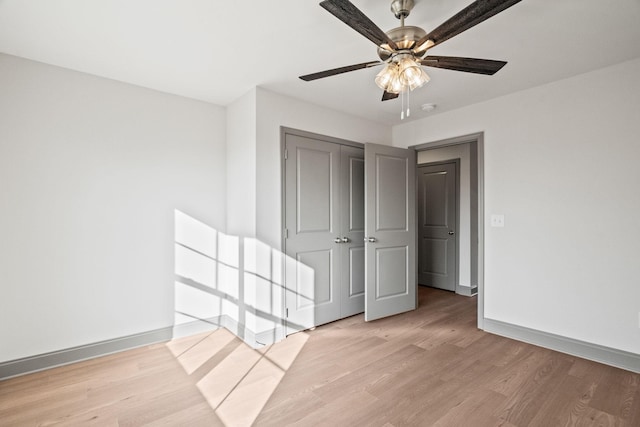 unfurnished bedroom with ceiling fan, a closet, and light hardwood / wood-style floors