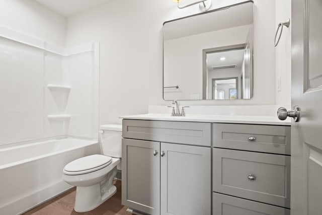 full bathroom with washtub / shower combination, wood-type flooring, vanity, and toilet