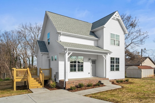 view of property with a front lawn, a deck, and a storage unit