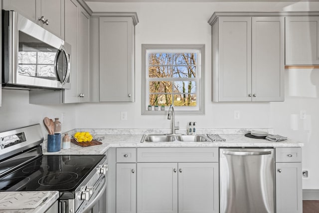 kitchen with gray cabinets, light stone countertops, sink, and appliances with stainless steel finishes