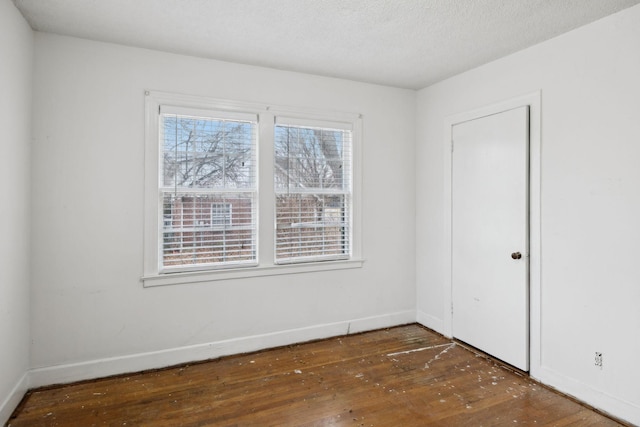 unfurnished room with dark hardwood / wood-style floors and a textured ceiling