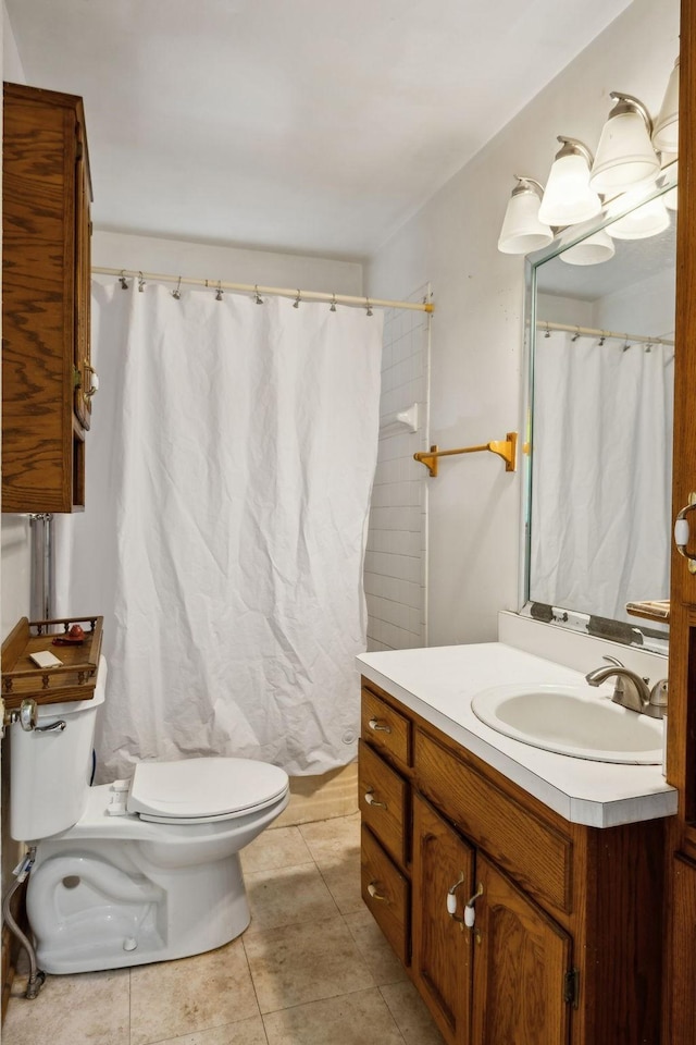 bathroom featuring vanity, tile patterned floors, and toilet