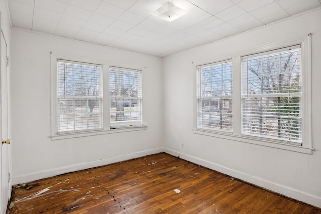 empty room featuring a wealth of natural light and dark hardwood / wood-style flooring