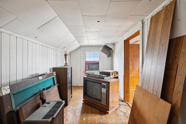 kitchen featuring hardwood / wood-style flooring, lofted ceiling, and wood walls