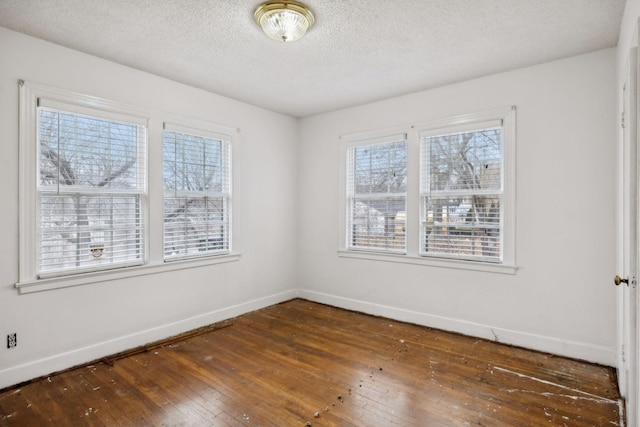 unfurnished room with a textured ceiling and dark hardwood / wood-style flooring