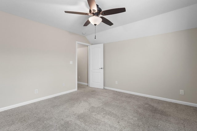 spare room featuring light colored carpet, vaulted ceiling, and ceiling fan