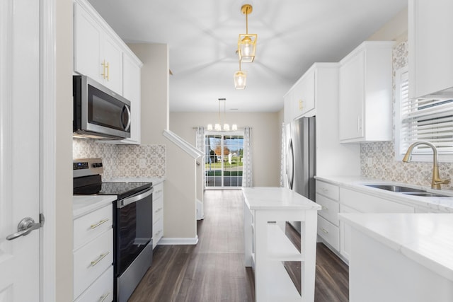 kitchen with pendant lighting, white cabinets, stainless steel appliances, and sink