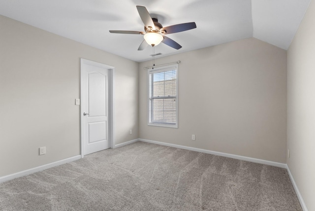 empty room featuring light colored carpet, vaulted ceiling, and ceiling fan