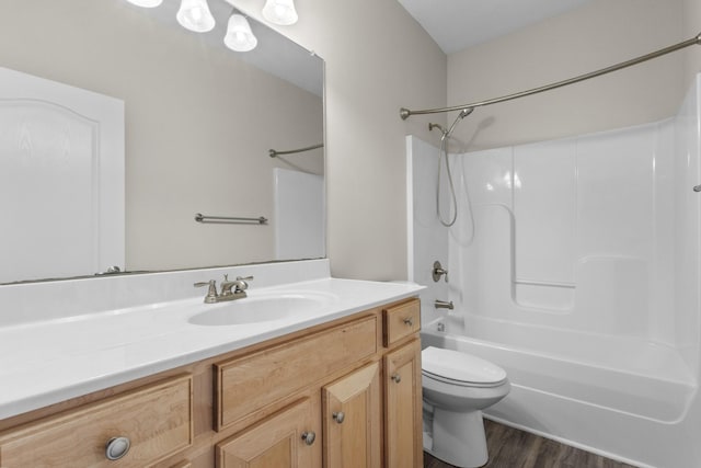 full bathroom with toilet, vanity,  shower combination, and hardwood / wood-style flooring