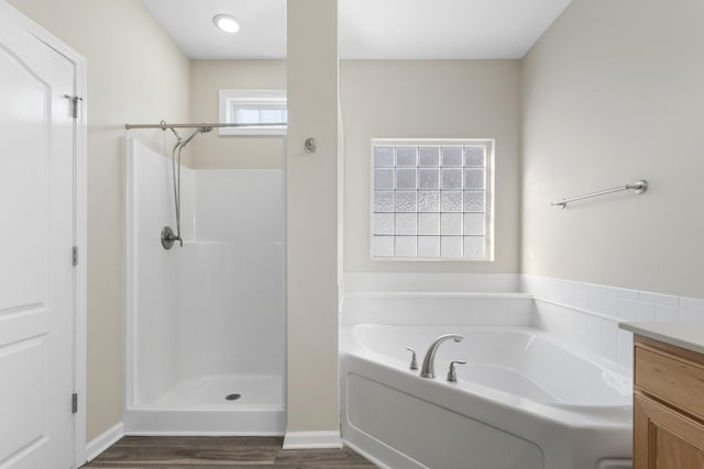 bathroom with hardwood / wood-style floors, vanity, and independent shower and bath